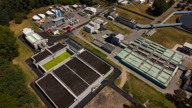 Aerial view of a modern wastewater treatment plant featuring large sedimentation tanks industrial infrastructure and surrounding green landscape in Milan Lombardy Italy. Aerial view of a modern wastewater treatment plant featuring large sedimentation tanks industrial infrastructure and surrounding green landscape in Milan Lombardy Italy.