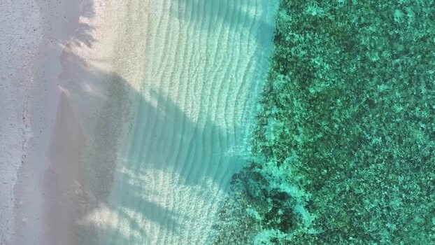Aerial view of turquoise ocean water meeting a white sandy beach Maldives. Aerial view of turquoise ocean water meeting a white sandy beach Maldives.