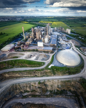Aerial view of Irish Cement Ltd industrial facility featuring tall chimneys and a large geodesic dome next to a limestone quarry Drogheda County Louth Ireland. Aerial view of Irish Cement Ltd industrial facility featuring tall chimneys and a large geodesic dome next to a limestone quarry Drogheda County Louth Ireland.