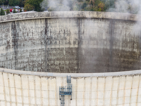 Aerial view of the concrete cooling tower at Heizkraftwerk Reuter West power plant with steam rising from the structure in Berlin Berlin Germany.
