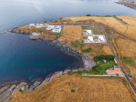 Aerial view of the Arapya coastal area featuring modern villas rocky shoreline and dry grassy fields in Burgas Bulgaria. Aerial view of the Arapya coastal area featuring modern villas rocky shoreline and dry grassy fields in Burgas Bulgaria.