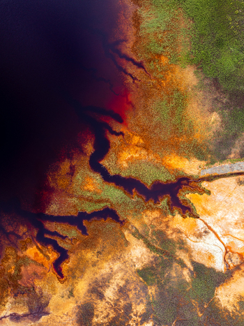 Aerial view of the vibrant red and orange mineral rich waters and surrounding landscape of the Rio Tinto in Andalusia Spain. Aerial view of the vibrant red and orange mineral rich waters and surrounding landscape of the Rio Tinto in Andalusia Spain.