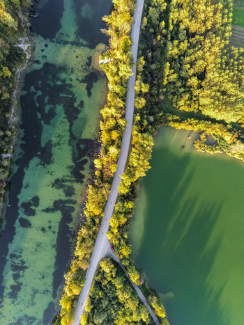 Aerial view of a road separating two lakes surrounded by autumn trees in Austria. Aerial view of a road separating two lakes surrounded by autumn trees in Austria.