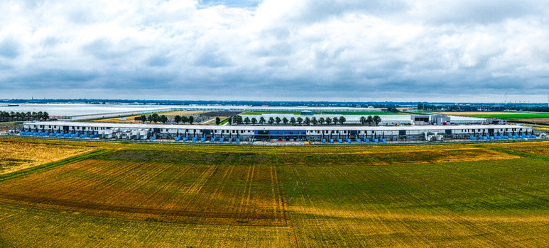 Aerial view of Agriport A7 a large industrial greenhouse complex surrounded by expansive agricultural fields under a cloudy sky in Middenmeer Noord Holland Netherlands. Aerial view of Agriport A7 a large industrial greenhouse complex surrounded by expansive agricultural fields under a cloudy sky in Middenmeer Noord Holland Netherlands.