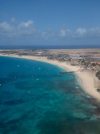 Aerial view of turquoise ocean water with numerous boats anchored near a white sandy beach and coastal buildings Santa Maria Sal Cabo Verde. Aerial view of turquoise ocean water with numerous boats anchored near a white sandy beach and coastal buildings Santa Maria Sal Cabo Verde.