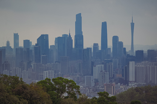 Aerial view of the modern skyline featuring the iconic Canton Tower and various skyscrapers under a hazy sky in Guangzhou Guangdong Province China. Aerial view of the modern skyline featuring the iconic Canton Tower and various skyscrapers under a hazy sky in Guangzhou Guangdong Province China.
