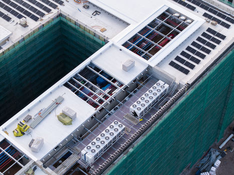 Aerial view of ai data center cooling system with industrial HVAC units solar panels and construction scaffolding on a rooftop in Krakow Lesser Poland Voivode Poland. Aerial view of ai data center cooling system with industrial HVAC units solar panels and construction scaffolding on a rooftop in Krakow Lesser Poland Voivode Poland.