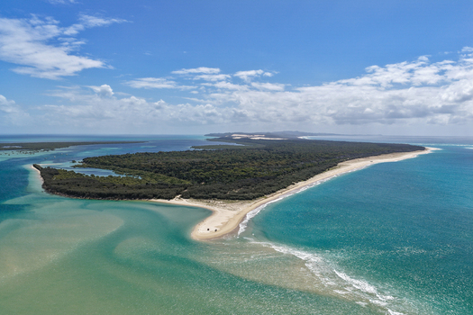 Aerial view of Moreton Island featuring the sandy spit of Kooringal turquoise coastal waters lush green vegetation and blue sky in Kooringal Queensland Australia. Aerial view of Moreton Island featuring the sandy spit of Kooringal turquoise coastal waters lush green vegetation and blue sky in Kooringal Queensland Australia.