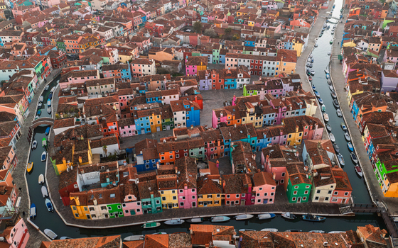 Aerial view of the colorful houses of Burano island in the Venetian Lagoon featuring vibrant building facades narrow canals and terracotta rooftops in Venice Veneto Italy. Aerial view of the colorful houses of Burano island in the Venetian Lagoon featuring vibrant building facades narrow canals and terracotta rooftops in Venice Veneto Italy.