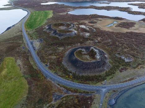 Aerial view of pseudo craters punctuate the landscape near Lake Myvatn where the road winds through the volcanic terrain Myvatn Þingeyjarsveit Iceland. Aerial view of pseudo craters punctuate the landscape near Lake Myvatn where the road winds through the volcanic terrain Myvatn Þingeyjarsveit Iceland.