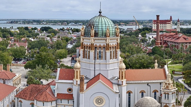 Aerial view of Memorial Presbyterian Church with its distinctive green dome and red tile roofs surrounded by the historic cityscape of St. Augustine Florida United States.