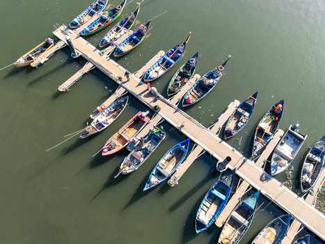 Aerial view of colorful boats nestled snugly along a pier reflecting the clear sky Porta de Abrigo da Torreira Aveiro Portugal. Aerial view of colorful boats nestled snugly along a pier reflecting the clear sky Porta de Abrigo da Torreira Aveiro Portugal.