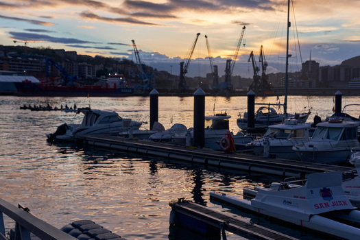 Pasai Donibane Spain 09 March 2026 View of Puerto Pasajes at sunset with docked boats in the marina and industrial cranes lining the harbor under a dramatic sky. Pasai Donibane Spain 09 March 2026 View of Puerto Pasajes at sunset with docked boats in the marina and industrial cranes lining the harbor under a dramatic sky.
