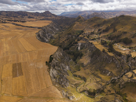 Aerial view of Toachi River Canyon featuring dramatic steep cliffs golden agricultural fields and winding river paths under a cloudy sky in Zumbahua Cotopaxi Ecuador. Aerial view of Toachi River Canyon featuring dramatic steep cliffs golden agricultural fields and winding river paths under a cloudy sky in Zumbahua Cotopaxi Ecuador.