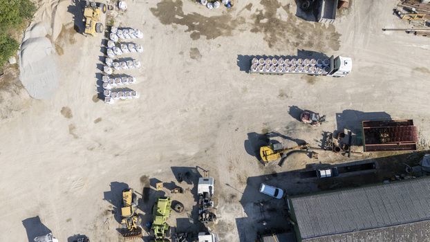 Aerial view of Extraccion de aridos Lima SL with heavy machinery trucks and stockpiles of materials at an industrial site in Vilarino das Poldras Ourense Spain. Aerial view of Extraccion de aridos Lima SL with heavy machinery trucks and stockpiles of materials at an industrial site in Vilarino das Poldras Ourense Spain.