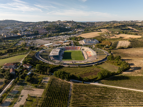 Aerial view of Stadio del Conero surrounded by agricultural fields vineyards and urban outskirts in Ancona Marche Italy. Aerial view of Stadio del Conero surrounded by agricultural fields vineyards and urban outskirts in Ancona Marche Italy.