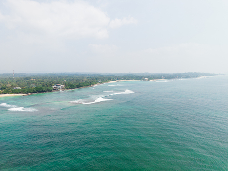 Aerial view of Devil s Rock coastline with turquoise ocean waves and lush palm trees Ahangama Southern Province Sri Lanka. Aerial view of Devil s Rock coastline with turquoise ocean waves and lush palm trees Ahangama Southern Province Sri Lanka.