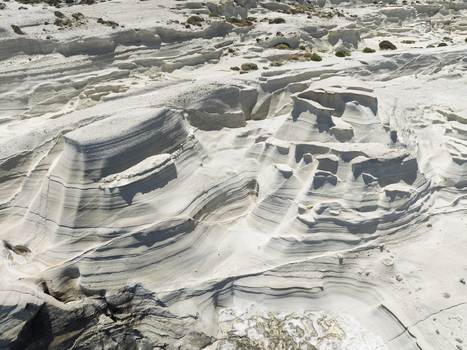 Aerial view of the white volcanic rock formations of Sarakiniko Beach with its lunar landscape and clear blue sea Milos Greece. Aerial view of the white volcanic rock formations of Sarakiniko Beach with its lunar landscape and clear blue sea Milos Greece.