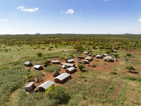 Aerial view of a rural village with small houses and metal roofs nestled in the arid savanna landscape of Marsabit County Kenya. Aerial view of a rural village with small houses and metal roofs nestled in the arid savanna landscape of Marsabit County Kenya.