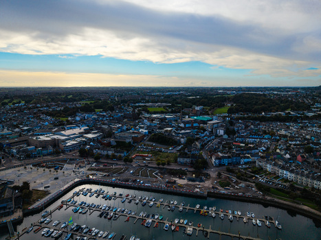 Aerial view of Bangor Harbour and Town with boats in the marina surrounded by urban buildings rooftops and green spaces in Bangor Northern Ireland United Kingdom.