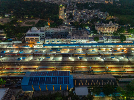 Aerial view of Udaipur railway station at night with illuminated train tracks passenger trains and a large building with solar panels on the roof in Udaipur Rajasthan India. Aerial view of Udaipur railway station at night with illuminated train tracks passenger trains and a large building with solar panels on the roof in Udaipur Rajasthan India.
