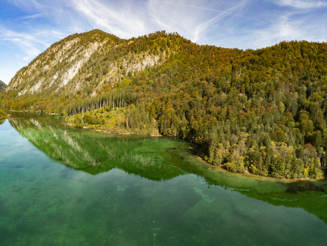 Aerial view of Attensee surrounded by dense forested mountains and clear green water in Rottenbach Bayern Germany. Aerial view of Attensee surrounded by dense forested mountains and clear green water in Rottenbach Bayern Germany.