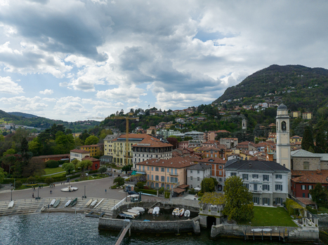 Aerial view of the historic Villa d Este and the terracotta rooftops along the waterfront with a church tower and small harbor in Cernobbio Lombardia Italy. Aerial view of the historic Villa d Este and the terracotta rooftops along the waterfront with a church tower and small harbor in Cernobbio Lombardia Italy.