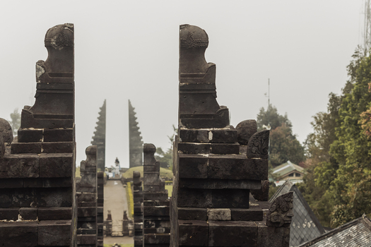 View of the ancient stone split gate of Cetho Temple surrounded by misty mountains and lush greenery in Kecamatan Jenawi Jawa Tengah Indonesia. View of the ancient stone split gate of Cetho Temple surrounded by misty mountains and lush greenery in Kecamatan Jenawi Jawa Tengah Indonesia.