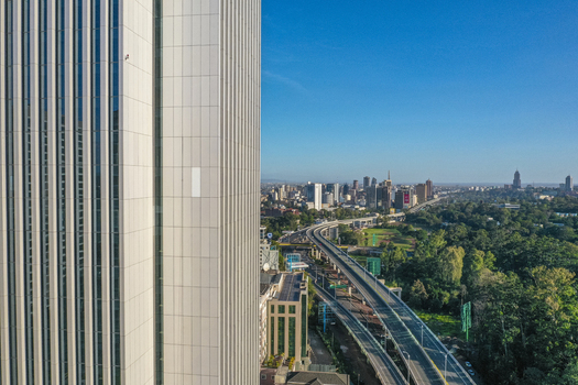 Aerial view of the modern skyscrapers in Westlands featuring a glass facade tower in the foreground and a highway winding through the urban landscape of Nairobi Nairobi County Kenya. Aerial view of the modern skyscrapers in Westlands featuring a glass facade tower in the foreground and a highway winding through the urban landscape of Nairobi Nairobi County Kenya.