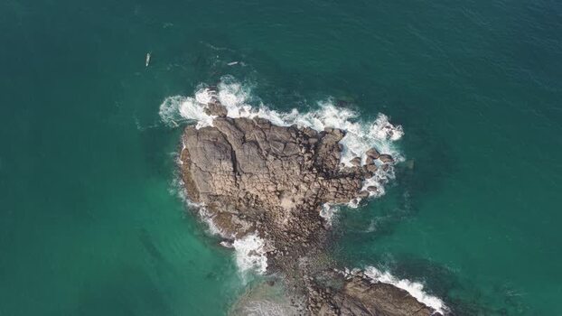 Aerial view of waves crashing on a rocky islet in the ocean India. Aerial view of waves crashing on a rocky islet in the ocean India.