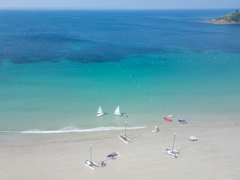 Aerial view of small sailboats and catamarans on a sandy beach with turquoise water and a clear blue sea Trebeurden Brittany France. Aerial view of small sailboats and catamarans on a sandy beach with turquoise water and a clear blue sea Trebeurden Brittany France.
