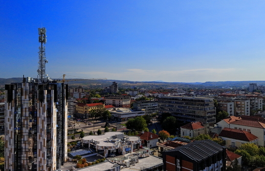 Aerial view of a modern high rise building with a telecommunications tower surrounded by urban architecture and residential rooftops in Krusevac Rasina District Serbia. Aerial view of a modern high rise building with a telecommunications tower surrounded by urban architecture and residential rooftops in Krusevac Rasina District Serbia.