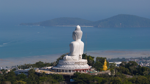 Aerial view of Big Buddha Phuket white marble statue on Nakkerd Hill overlooking the turquoise sea and distant islands with people on the observation deck Karon Phuket Thailand. Aerial view of Big Buddha Phuket white marble statue on Nakkerd Hill overlooking the turquoise sea and distant islands with people on the observation deck Karon Phuket Thailand.