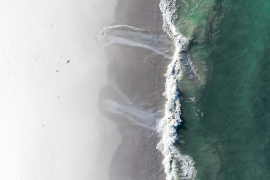 Aerial view of white sand beach meeting turquoise ocean waves with white foam in Cape Town Western Cape South Africa. Aerial view of white sand beach meeting turquoise ocean waves with white foam in Cape Town Western Cape South Africa.