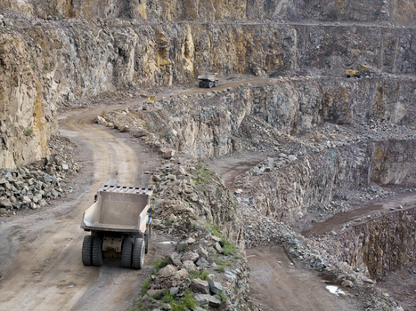Aerial view of the Porphyry Mine Zalas featuring large dump trucks navigating dirt roads along the rocky terraced walls of the open pit mining site in Frywald Wojewodztwo malopolsk Poland.