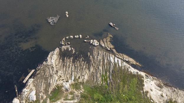 Danau Kerinci Jambi Indonesia 25 September 2026 Aerial view of the rocky shoreline and clear waters of Danau Kerinci with sparse vegetation and a small wooden boat. Danau Kerinci Jambi Indonesia 25 September 2026 Aerial view of the rocky shoreline and clear waters of Danau Kerinci with sparse vegetation and a small wooden boat.