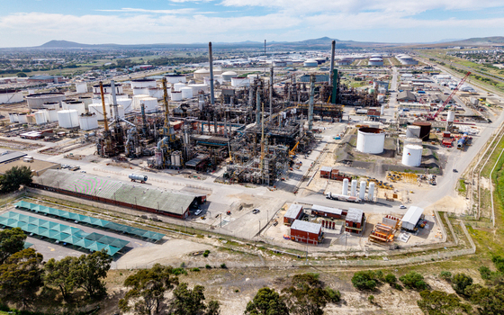 Aerial view of the Milnerton oil refinery featuring industrial storage tanks complex piping systems and tall chimneys in Cape Town Western Cape South Africa. Aerial view of the Milnerton oil refinery featuring industrial storage tanks complex piping systems and tall chimneys in Cape Town Western Cape South Africa.