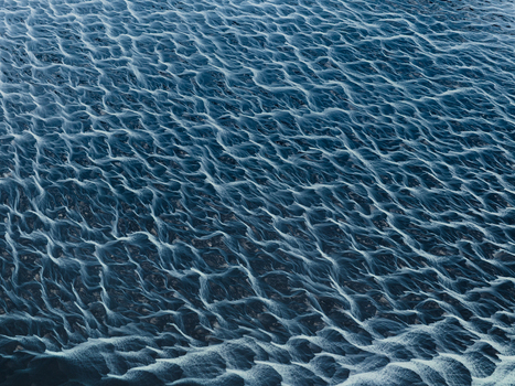 Aerial view of dark sandy terrain etched with delicate frost kissed rivulets creates an intricate tapestry of shadow and light Iceland Iceland. Aerial view of dark sandy terrain etched with delicate frost kissed rivulets creates an intricate tapestry of shadow and light Iceland Iceland.