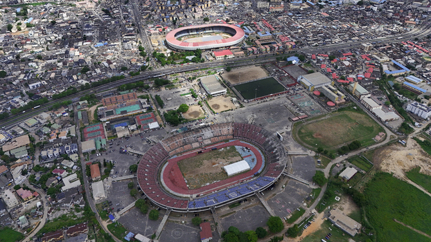 Aerial view of the National Stadium Surulere Lagos and surrounding sports facilities amidst the dense urban landscape of Lagos Lagos Nigeria. Aerial view of the National Stadium Surulere Lagos and surrounding sports facilities amidst the dense urban landscape of Lagos Lagos Nigeria.