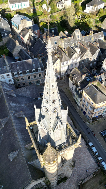 Aerial view of the ornate stone spire of Eglise Saint Melaine de Morlaix overlooking historic slate roofed houses and narrow streets Morlaix Bretagne France. Aerial view of the ornate stone spire of Eglise Saint Melaine de Morlaix overlooking historic slate roofed houses and narrow streets Morlaix Bretagne France.