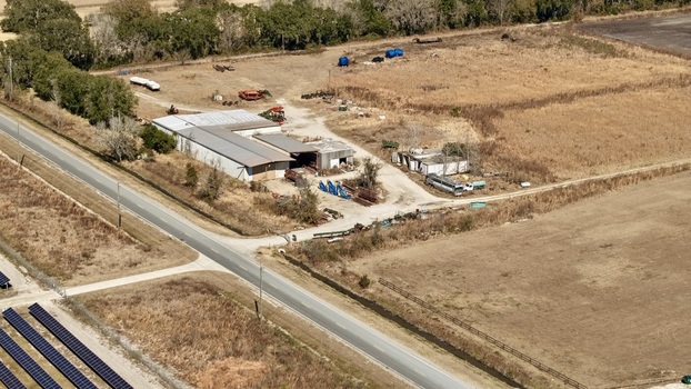 Aerial view of farm buildings and agricultural land meet the stark contrast of a solar panel array Elkton Florida United States. Aerial view of farm buildings and agricultural land meet the stark contrast of a solar panel array Elkton Florida United States.