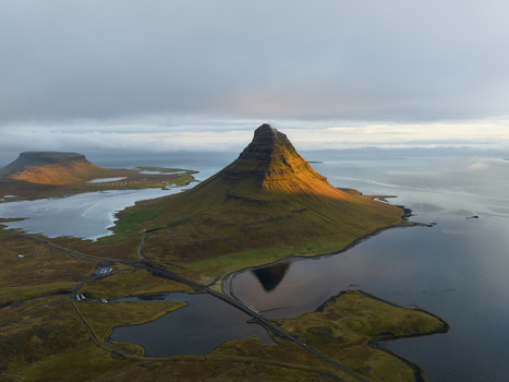Aerial view of Kirkjufell mountain rising majestically where the sea meets the land a symphony of green and blue hues Grundarfjordur Iceland. Aerial view of Kirkjufell mountain rising majestically where the sea meets the land a symphony of green and blue hues Grundarfjordur Iceland.