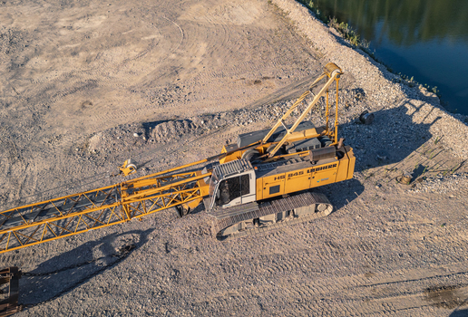 Le Pouzin Auvergne Rhone Alpes France 04 July 2026 Aerial view of a Liebherr HS 845 crawler crane operating at a quarry site with gravel ground and a nearby pond. Le Pouzin Auvergne Rhone Alpes France 04 July 2026 Aerial view of a Liebherr HS 845 crawler crane operating at a quarry site with gravel ground and a nearby pond.