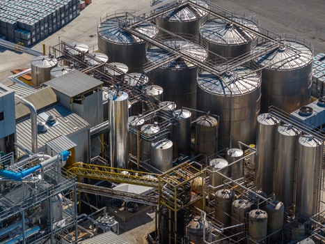 Aerial view of an industrial facility featuring large stainless steel storage tanks complex piping systems and metal catwalks in Spoleto Umbria Italy. Aerial view of an industrial facility featuring large stainless steel storage tanks complex piping systems and metal catwalks in Spoleto Umbria Italy.