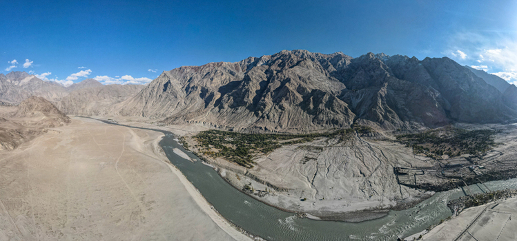 Aerial view of the Indus River flowing through the rugged mountain landscape with sandy banks and rocky terrain in Skardu Gilgit Pakistan.