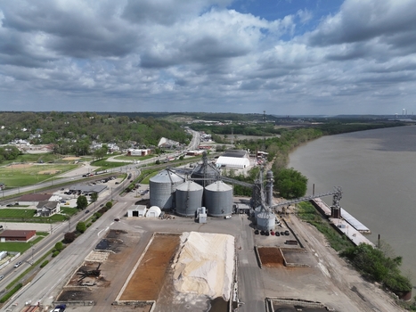 Aerial view of large industrial grain silos and storage facilities situated along a riverbank under a cloudy sky Aurora Indiana United States. Aerial view of large industrial grain silos and storage facilities situated along a riverbank under a cloudy sky Aurora Indiana United States.