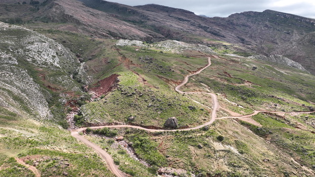 Aerial view of the rugged mountainous landscape of Torotoro with a winding dirt road cutting through the green hills and rocky terrain in Torotoro Potosi Department Bolivia. Aerial view of the rugged mountainous landscape of Torotoro with a winding dirt road cutting through the green hills and rocky terrain in Torotoro Potosi Department Bolivia.