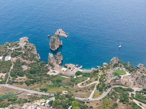 Aerial view of Riserva Naturale Orientata dello Zingaro featuring dramatic rocky cliffs turquoise sea ancient watchtower and winding coastal roads San Vito Lo Capo Sicilia Italy. Aerial view of Riserva Naturale Orientata dello Zingaro featuring dramatic rocky cliffs turquoise sea ancient watchtower and winding coastal roads San Vito Lo Capo Sicilia Italy.