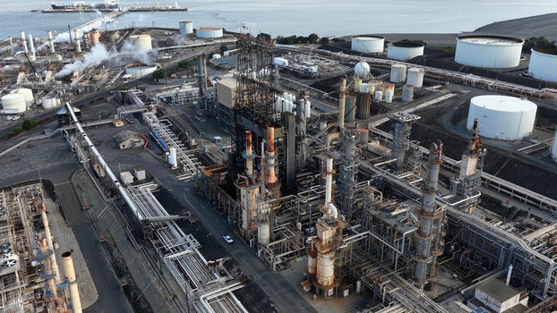 Aerial view of the Phillips 66 oil refinery featuring complex industrial piping distillation towers and large storage tanks near the waterfront in Rodeo California United States.
