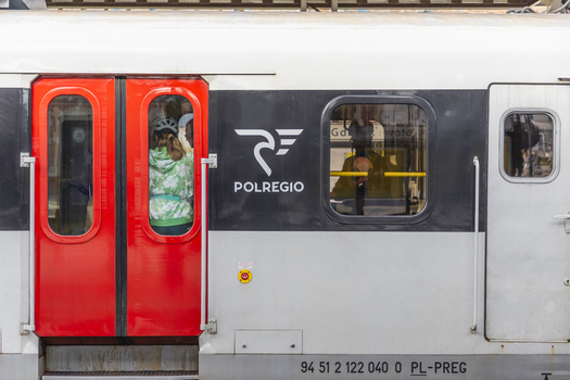 Gdansk Poland 06 September 2026 View of a Polregio train carriage with bright red doors and a passenger visible through the window at a station. Gdansk Poland 06 September 2026 View of a Polregio train carriage with bright red doors and a passenger visible through the window at a station.
